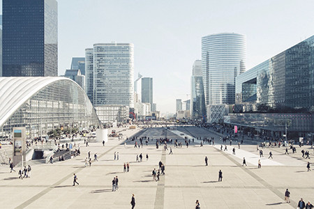 High Angle View Of People On Street Amidst Modern Buildings Against Clear Sky