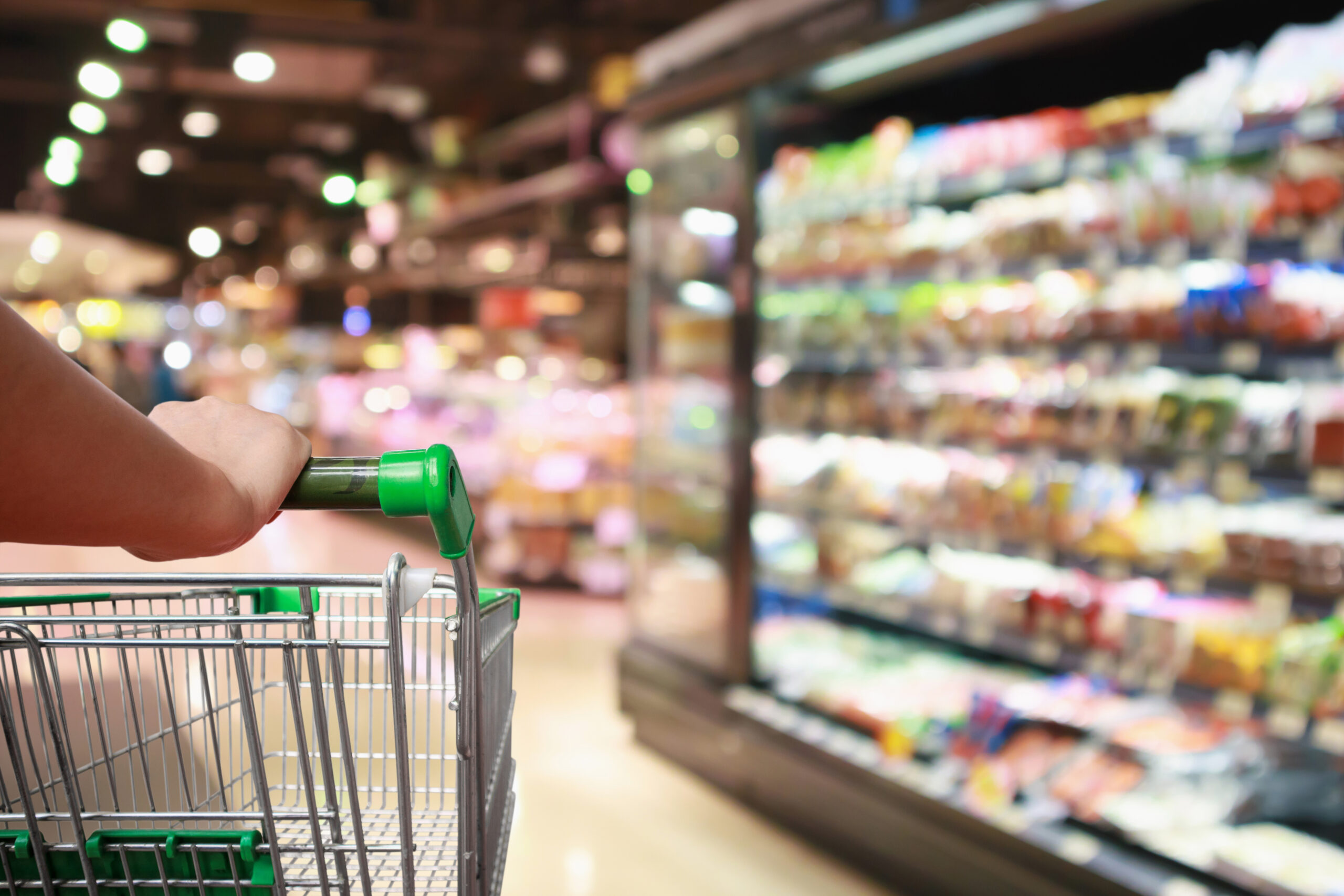 Woman Hand Hold Supermarket Shopping Cart With Abstract Grocery