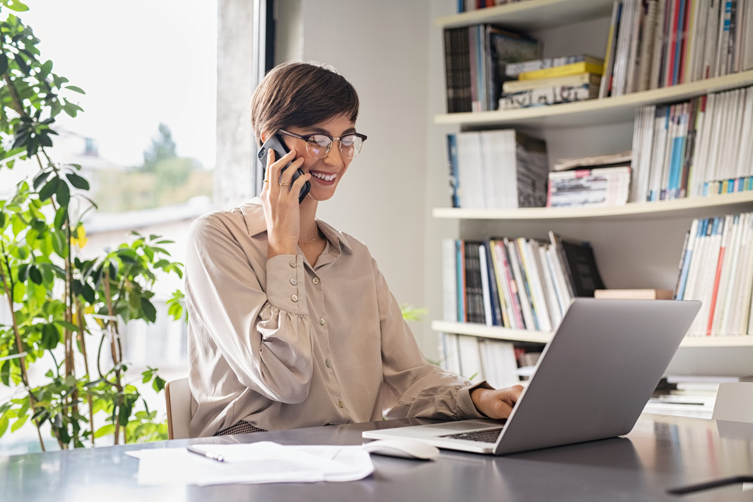 Business Woman Using Laptop And Talking On Phone